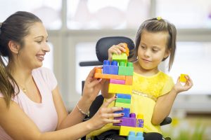 Child with cerebral palsy spending time with adults